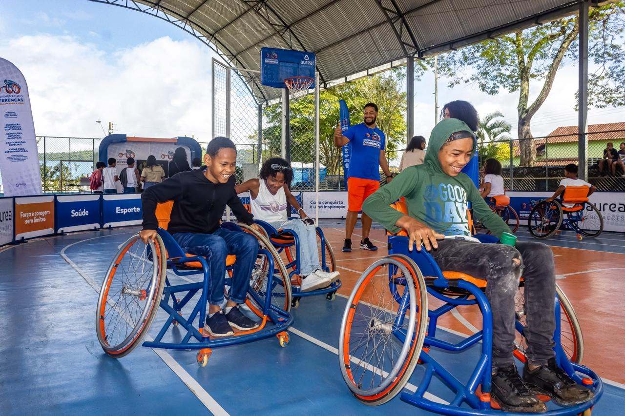 Crianças cadeirantes em uma corrida em circuito oval na quadra de esportes
